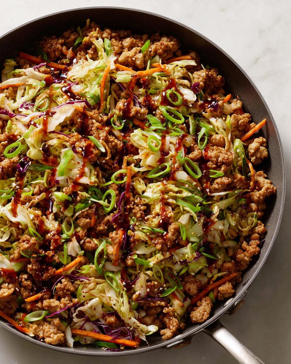A close-up of a 20-minute pork skillet with cabbage, carrots, and a savory sauce, perfect for quick dinner ideas.