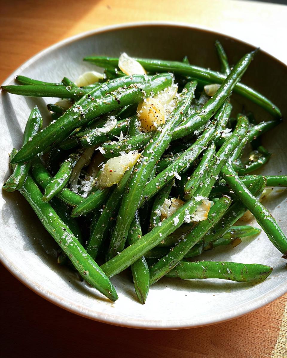 A close-up of vibrant green beans seasoned with salt, pepper, and garlic, ready for Thanksgiving.