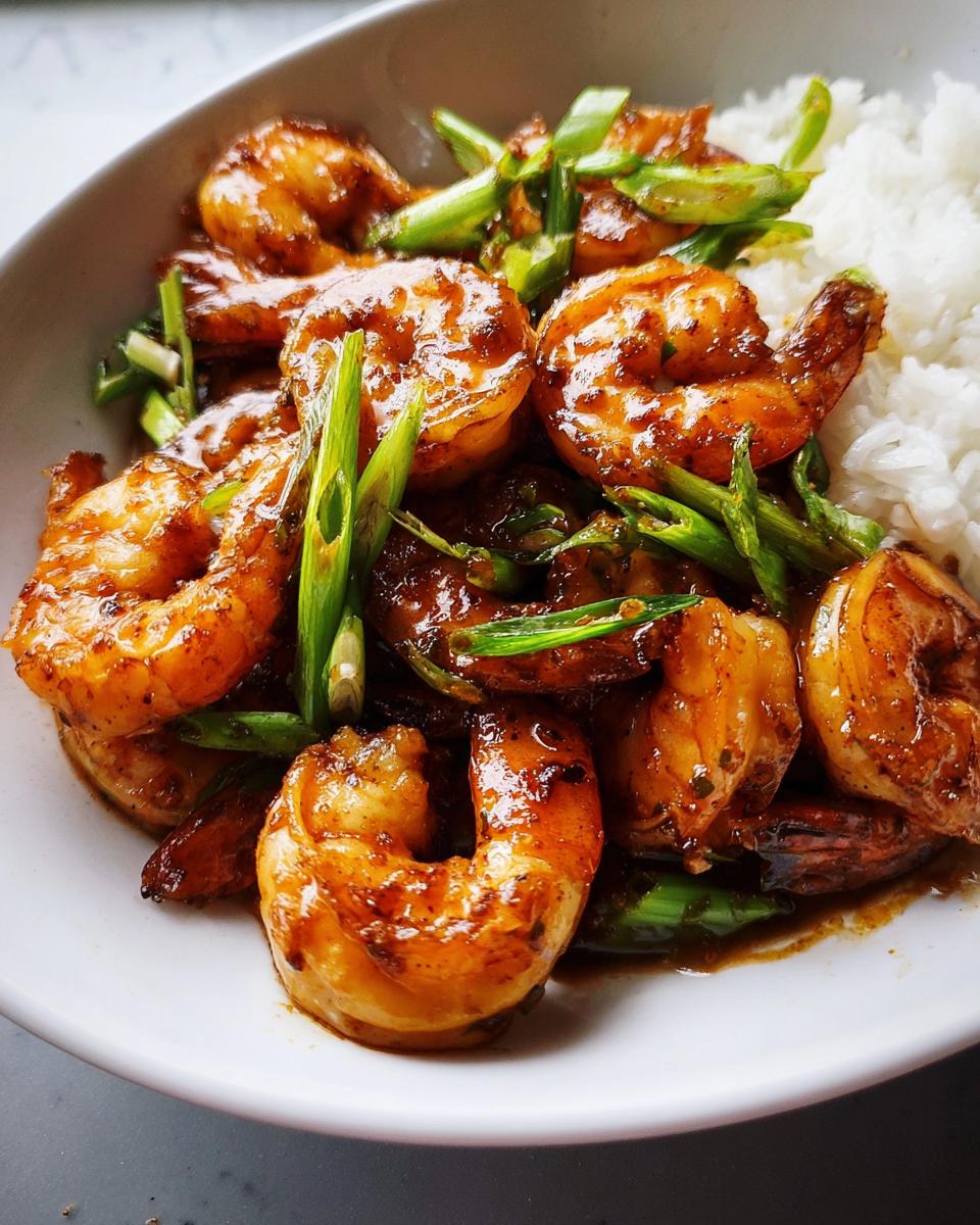 Close-up of delicious Honey Garlic Shrimp Bowls with fluffy white rice and chopped green onions.
