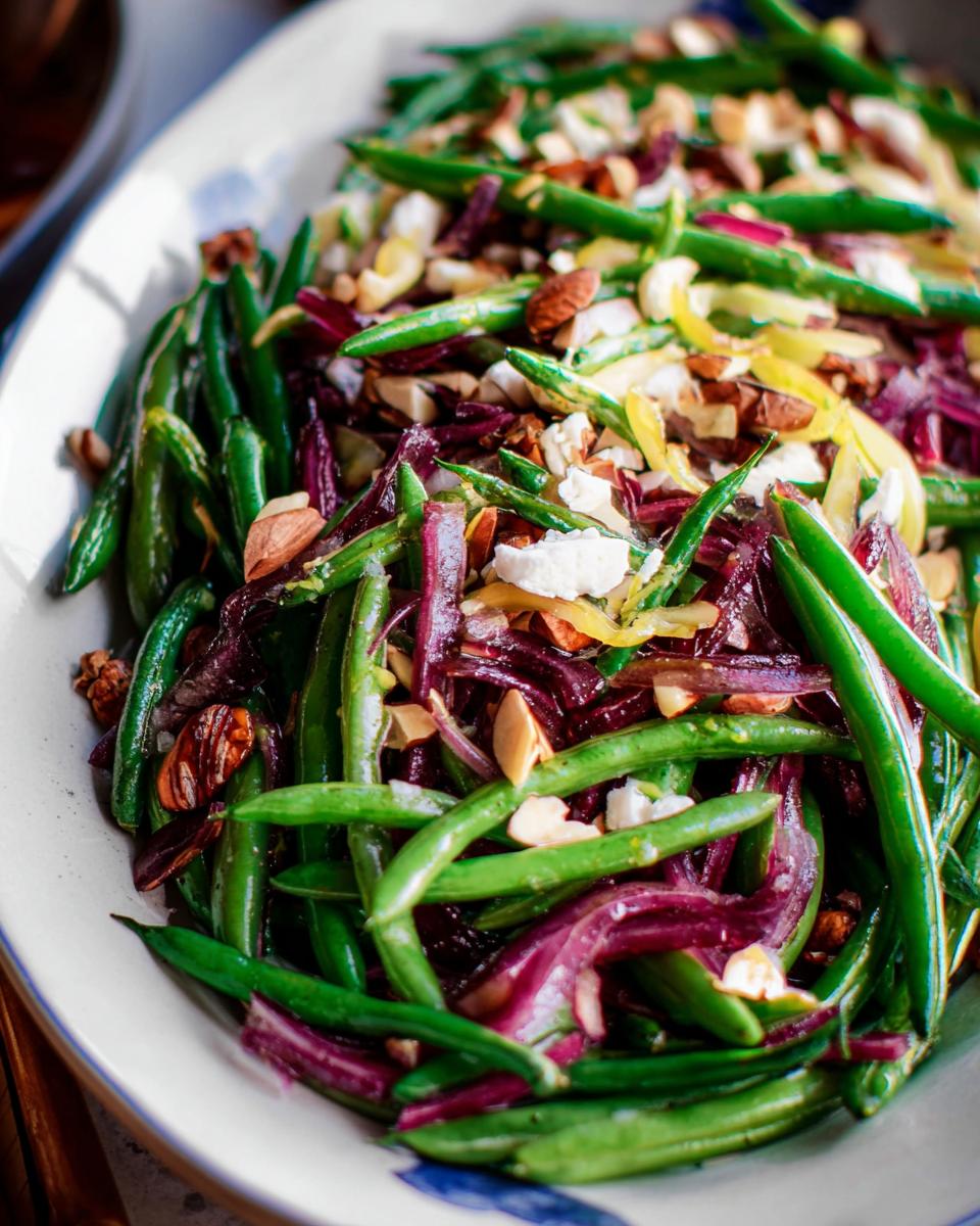 A vibrant Thanksgiving salad featuring crisp green beans, red onion, almonds, and crumbled cheese.