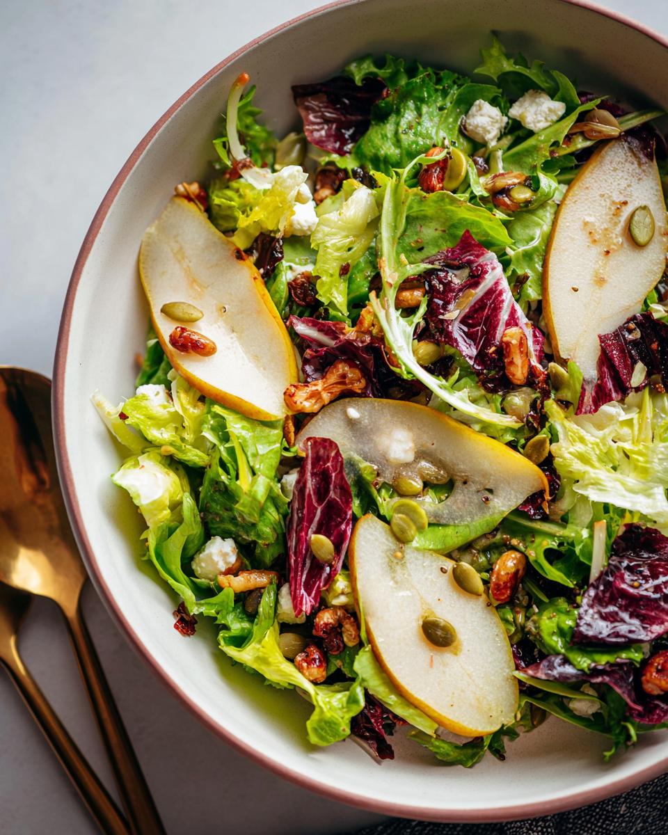 A vibrant Thanksgiving salad recipe featuring crisp lettuce, radicchio, sliced pears, crumbled cheese, walnuts, and pumpkin seeds.