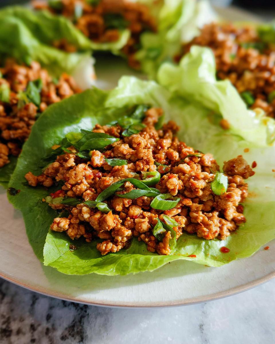Close-up of delicious Turkey Lettuce Wraps (PF-Style) filled with seasoned ground turkey and topped with green onions.
