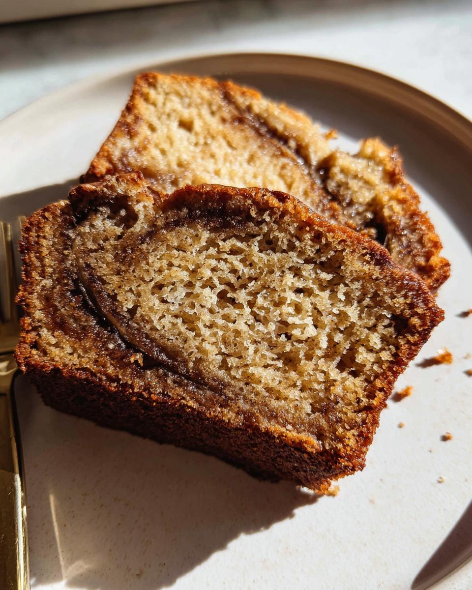 Two slices of moist Cinnamon Swirl Banana Bread showing the rich, dark cinnamon swirl texture inside.