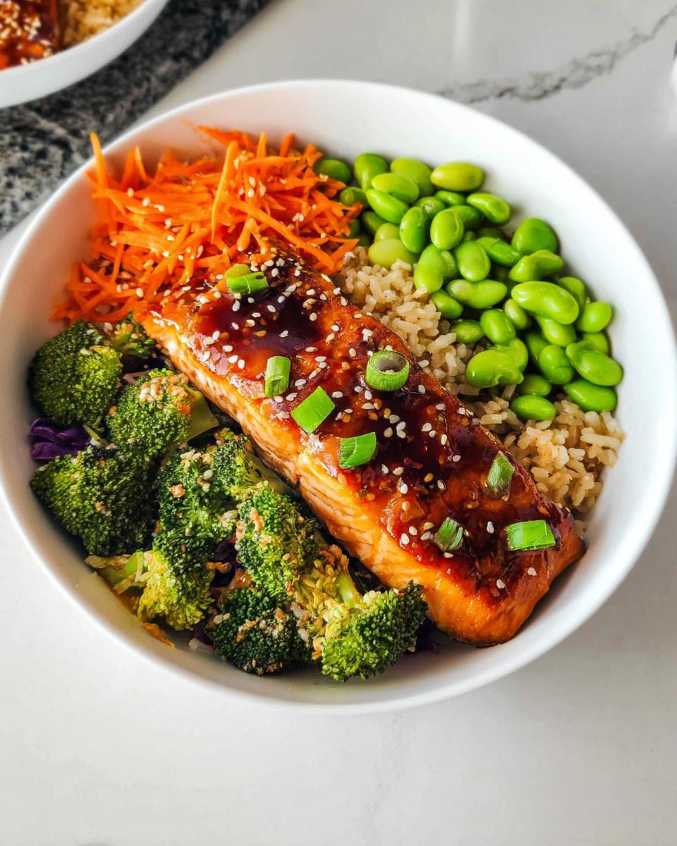 Close-up of a Healthy Teriyaki Salmon and Broccoli Bowl featuring glazed salmon, brown rice, edamame, and shredded carrots.