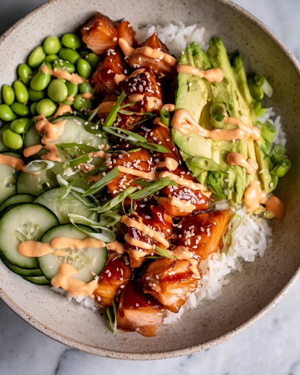 Close-up of Teriyaki Glazed Salmon Rice Bowls featuring glazed salmon, avocado, edamame, and cucumber.