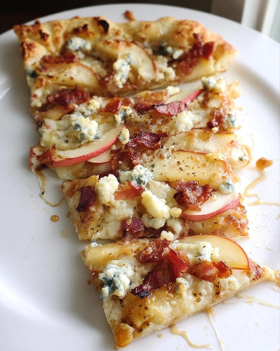 Slices of apple, bacon, and blue cheese pizza on a white plate, part of 10-Ingredient Pizza Night Recipes.