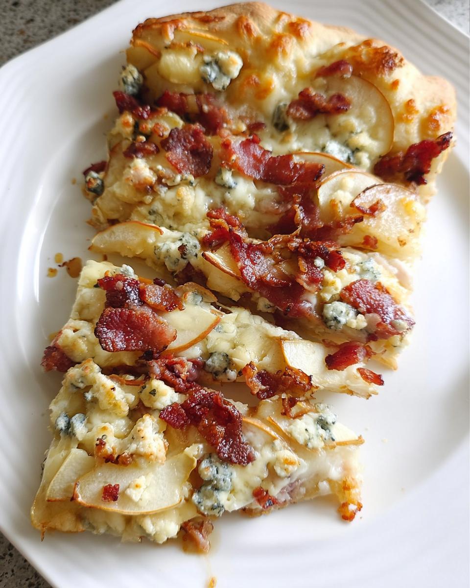 A slice of pear and bacon pizza with blue cheese and melted mozzarella, part of 10-Ingredient Pizza Night Recipes.