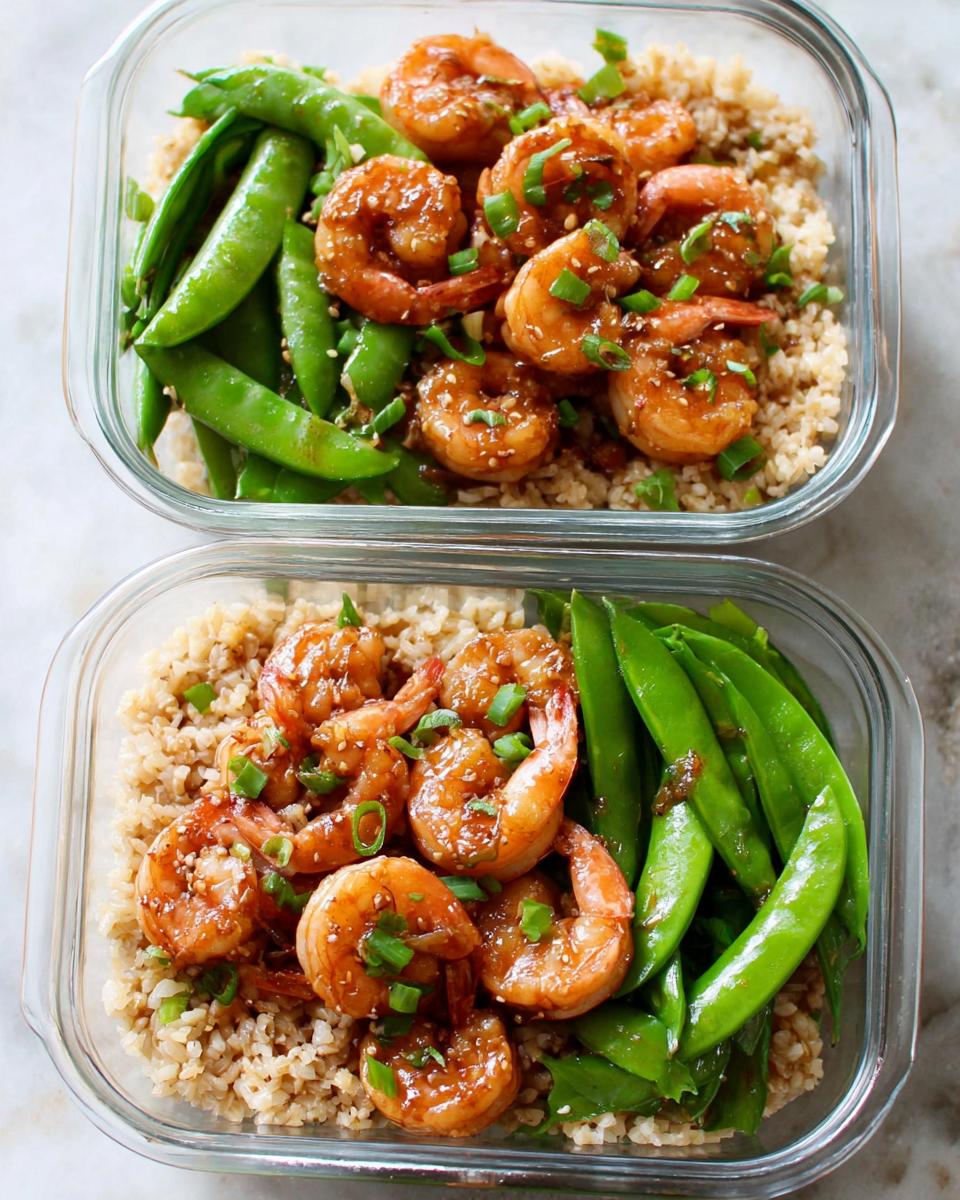 Two meal prep containers filled with shrimp recipes, brown rice, and snow peas, perfect for a healthy meal prep.