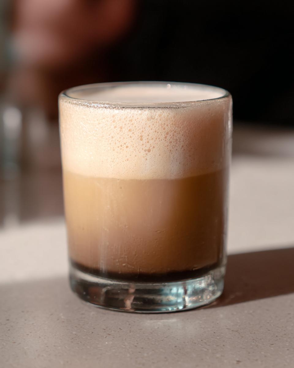 A close-up of a layered iced coffee drink, part of 10 Genius Starbucks Drinks Recipes Ideas for Busy Weeknights.