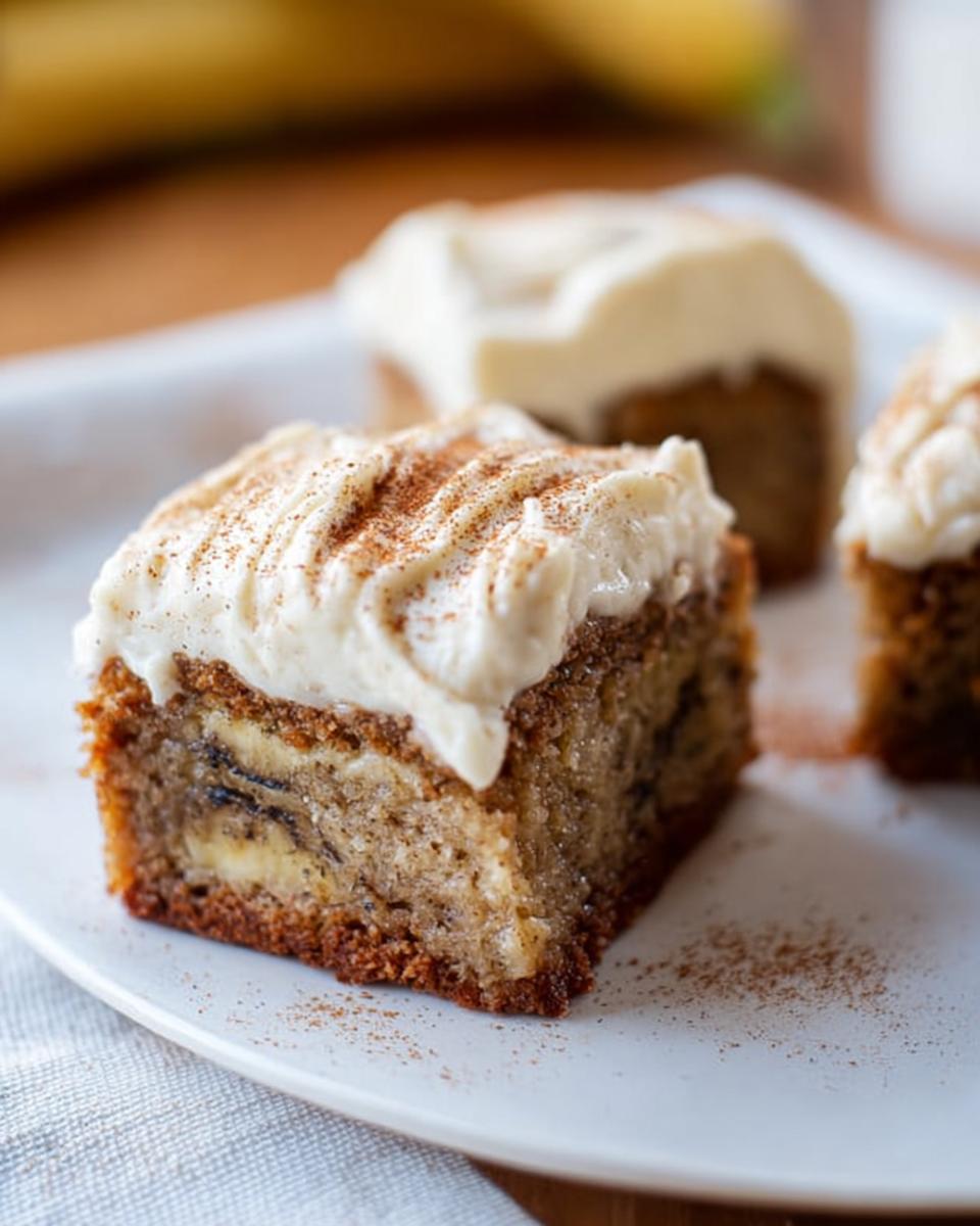 Close-up of a square Banana Bread Brownie Made Easy, topped with cream cheese frosting and a sprinkle of cinnamon.