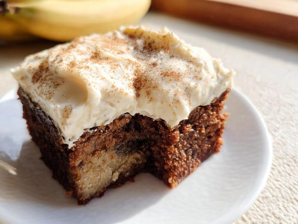 A delicious slice of Banana Bread Brownies Made Easy, topped with creamy frosting and a sprinkle of cinnamon.