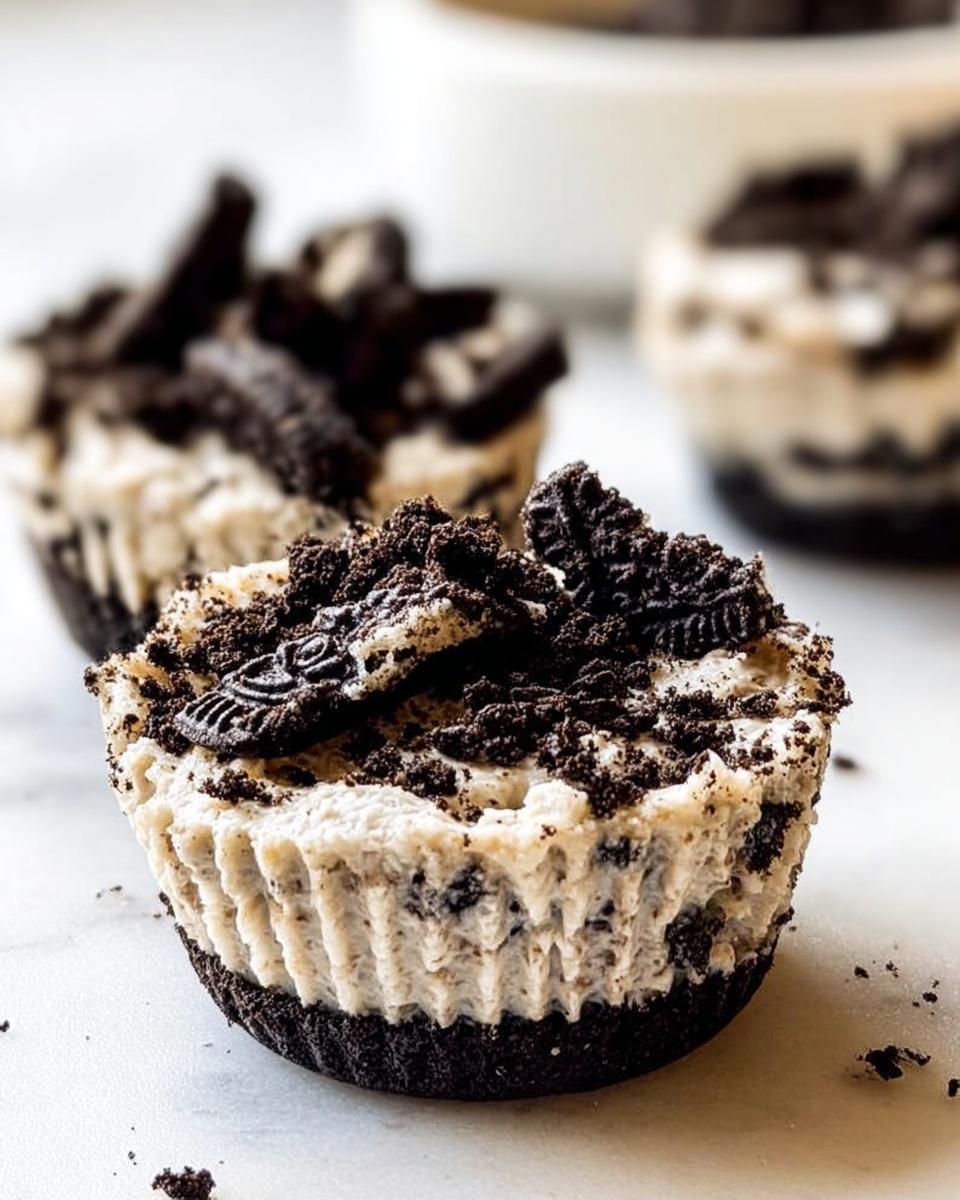 Close-up of a healthy no-bake Oreo cheesecake bite topped with crushed Oreos and Oreo pieces.