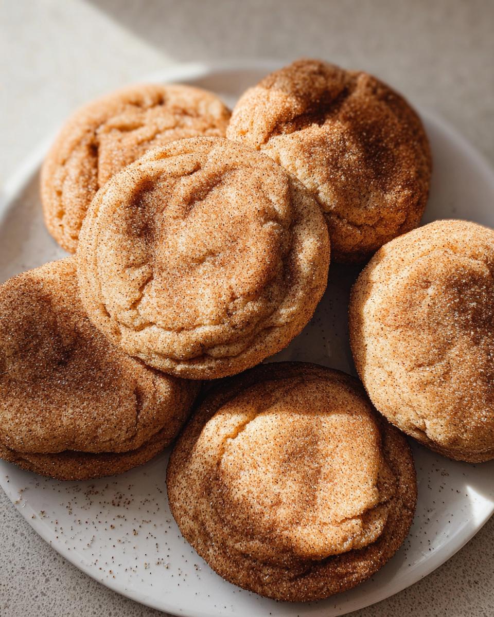 A close-up of several Chewy Churro Cookies that taste like a warm hug, dusted with cinnamon sugar.