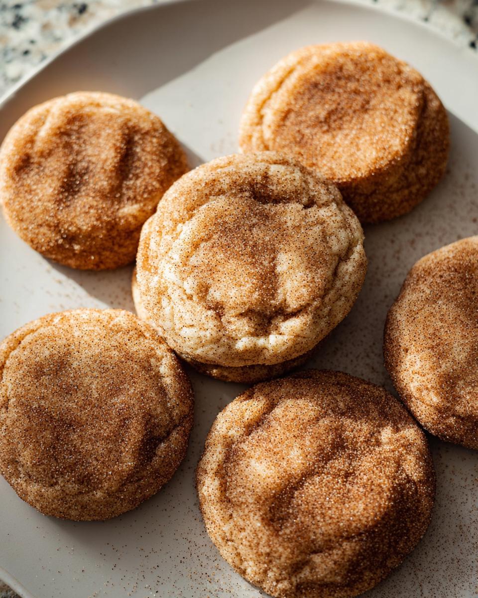 A plate of freshly baked chewy churro cookies, coated in cinnamon sugar.