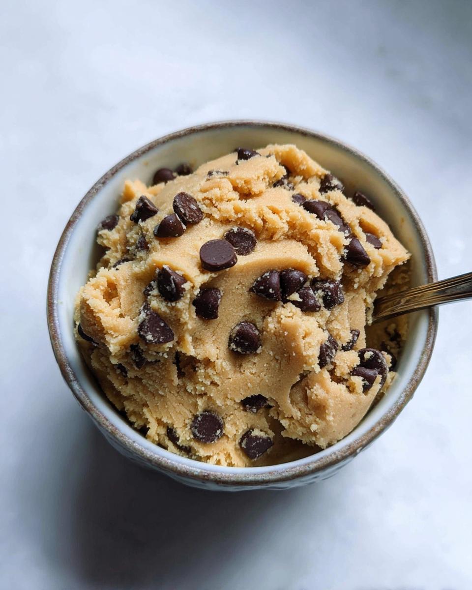A bowl of delicious protein cookie dough loaded with chocolate chips, ready to be enjoyed.
