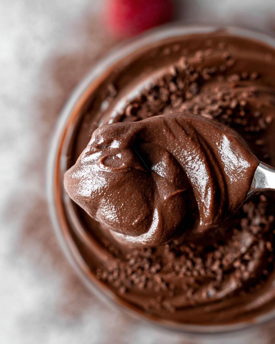 A spoonful of creamy High Protein Chocolate Pudding, topped with chocolate shavings.