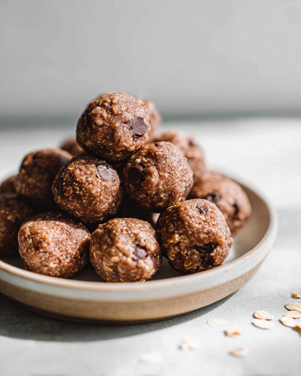 A pile of delicious no-bake chocolate peanut butter protein balls with chocolate chips.
